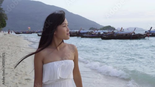 Young asian woman walking on the beach.