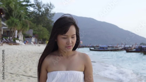 Young asian woman walking on the beach.