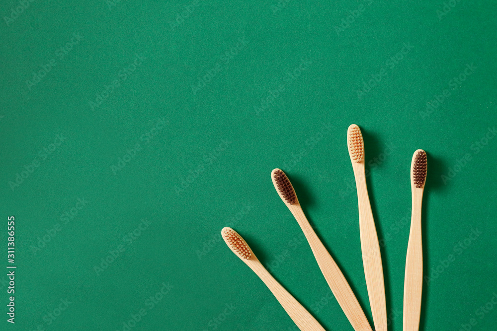 Top view or flat lay concept with eco bamboo tree toothbrushes on green background. Concept of zero waste and caring for environment Top view or flat lay concept with eco bamboo tree toothbrushes on green background. Concept of zero waste and caring for environment