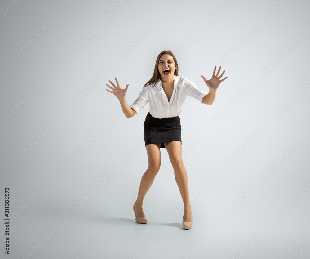 Best goalkeeper. Woman in office clothes catching ball on grey studio background. Businesswoman training in motion, action. Unusual look for sport, new activity. Sport, football, healthy lifestyle. Best goalkeeper. Woman in office clothes catching ball on grey studio background. Businesswoman training in motion, action. Unusual look for sport, new activity. Sport, football, healthy lifestyle.