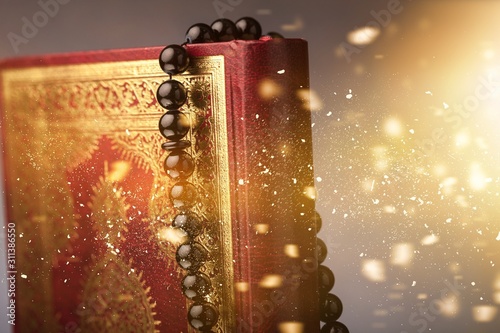 Islamic Book Koran with rosary on grey background