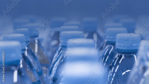 Defocus background plastic bottles of water. Color of the Year 2020 Classic Blue backdrop background wallpaper  photo tinted in trendy blue color