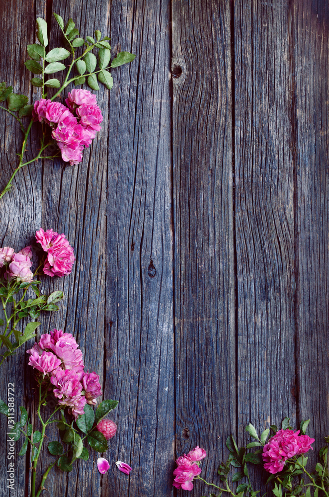 wooden rustic old table texture with foliage frame and pink flowers