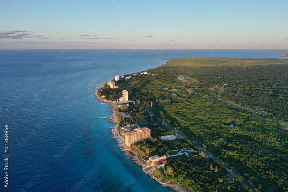 Coast line of Cozumel island with beach front hotels, tropical forest and turquoise blue Caribbean Sea
