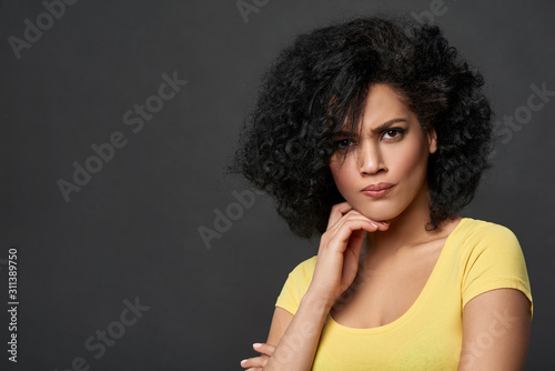 Discontent frowning mixed race woman looking at camera