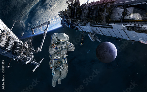 Fototapeta Naklejka Na Ścianę i Meble -  Astronaut, ISS in orbit of Earth. Moon. Solar system. Science fiction. Elements of this image furnished by NASA