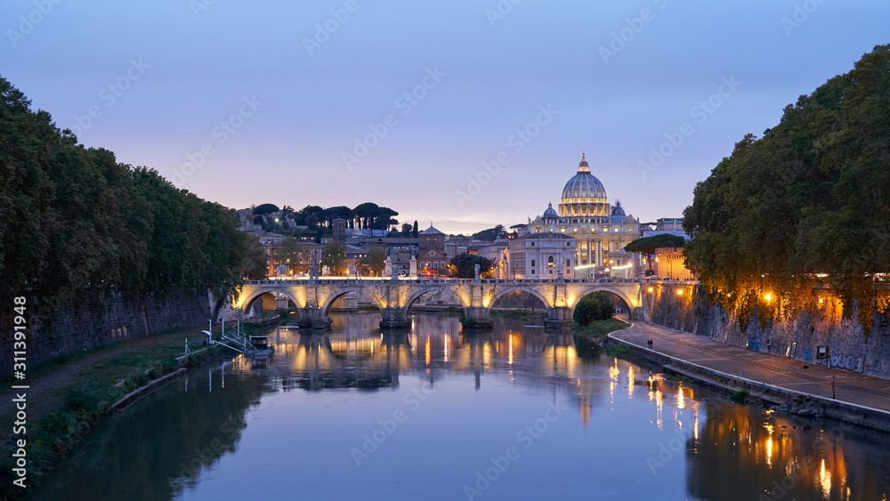 St. Angelo bridge over the Tiber river and St. Peter's Dome in Rome at sunset, Italy.