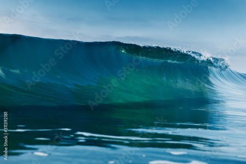 Blue crystal wave in ocean. Breaking wave and sun light