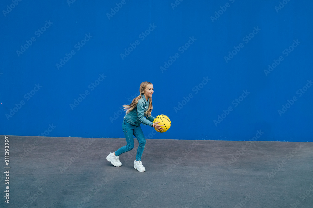 Little girl playing with the yellow ball