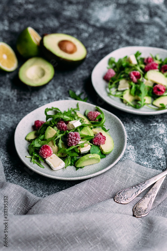 Salad with arugula, avocado, raspberries and brie cheese
