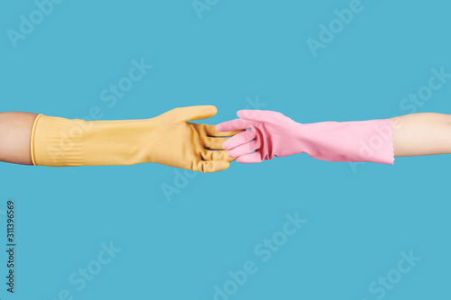 People in rubber gloves outstretching hands for handshake