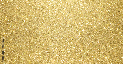 Gold glitter background with sparkling texture. Golden shimmering light, stars sequins sparks and glittering glow foil background photo