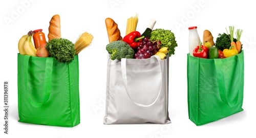 Bag full of groceries on wooden desk with pastel background
