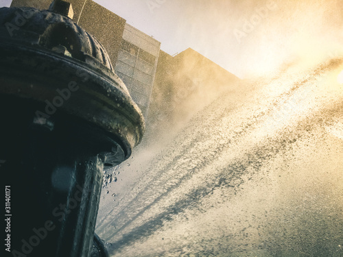 A Fire Hydrant spraying on people on a hot day in new york city photo