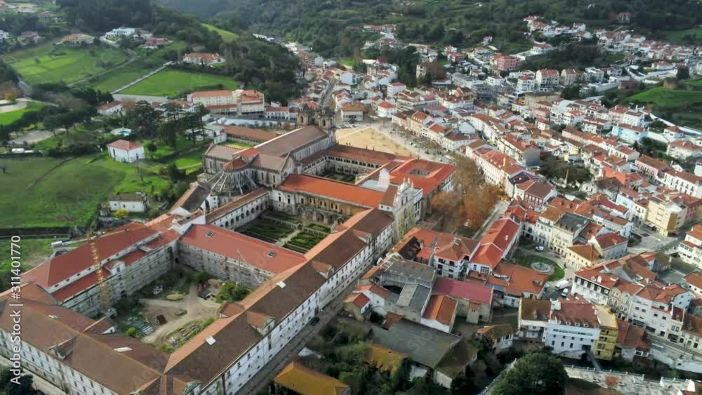 Aerial view of the Alcobaca Monastery and the city. Leiria Portugal. Mediaeval Roman Catholic Architecture. Green hills in the background. 4k drone footage, pan Aerial view of the Alcobaca Monastery and the city. Leiria Portugal. Mediaeval Roman Catholic Architecture. Green hills in the background. 4k drone footage, pan