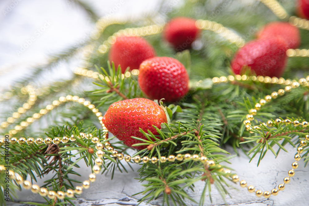 A beautiful sprig of spruce decorated with strawberries. Fresh strawberries close-up, decoration for the Christmas tree. A beautiful sprig of spruce decorated with strawberries. Fresh strawberries close-up, decoration for the Christmas tree.