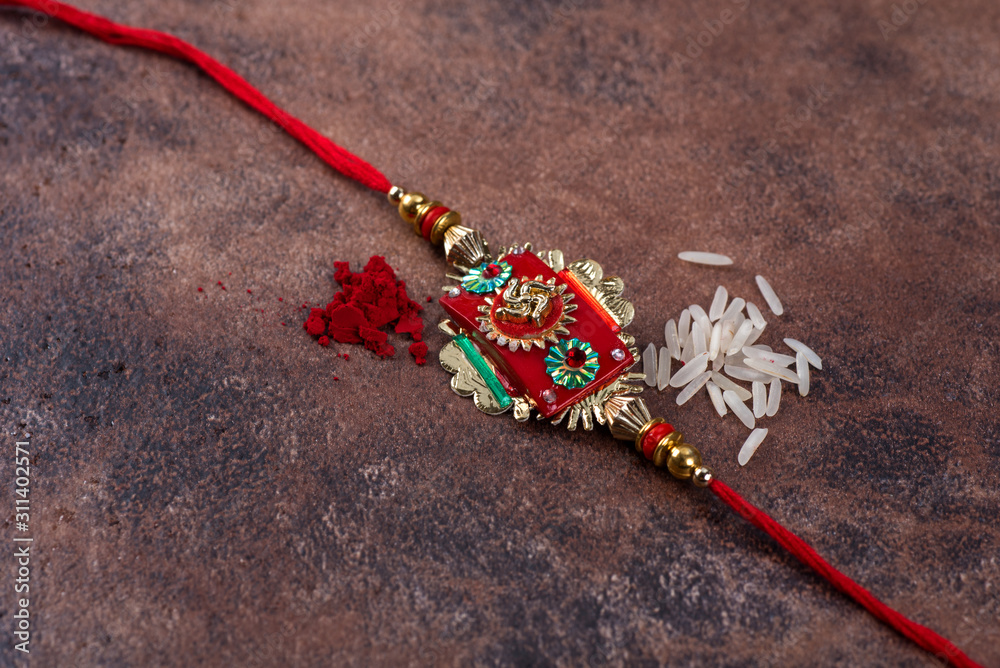 Raksha Bandhan : Rakhi with rice grains and kumkum on stone background ...