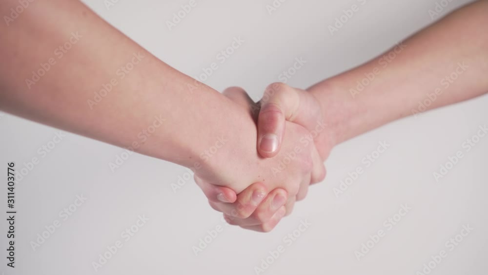 Handshake of two teenagers on a white background. Close-up. The concept of friendship and communication in social networks and daily life.