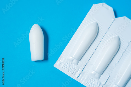 Foto White suppositories for anal or vaginal use on blue background