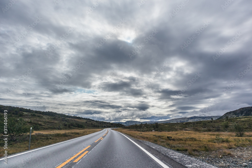 Mountains in Norway road epic scenic sky, way, clouds view. Traveling by car, driving nature tourism. Dramatic skyscape northern scandinavian sky