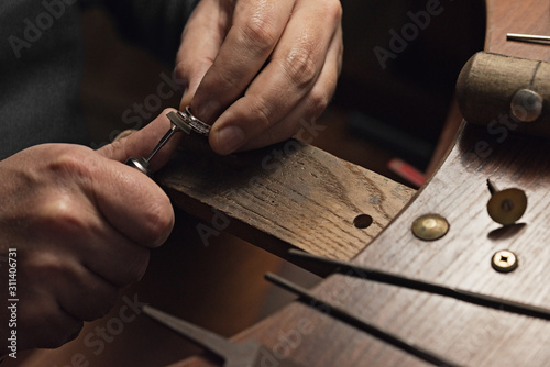 Jewelry craftsmanship. Handmade. Jeweler at work. The jeweler polishes a white gold ring with diamonds. Desktop with work tools. photo