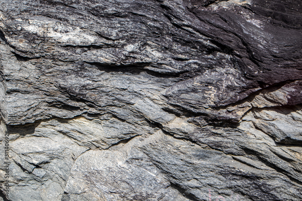 Grey black granite stone on natural wall in mountains. Close up gray texture, rough surface material. For design, web Grey black granite stone on natural wall in mountains. Close up gray texture, rough surface material. For design, web