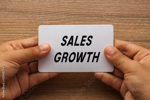 Sales Growth written on white card holding with two hands