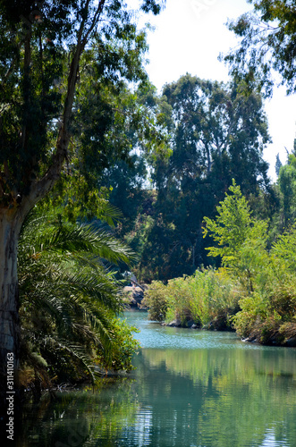 Place of Baptism Yardenit. Located along the Jordan River in the Galilee region of northern Israel. Clean, calm water, green palm trees along the shores. photo