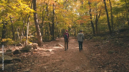 Scenic cinematic slow motion video of two tourists walking of path in mountains of Dinosaur Ridge in Seoraksan national park near Sokcho in South Korea. Beautiful summer look of trail in forest