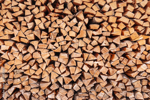 Fototapeta dry chopped wood stacked in a woodpile, as a background