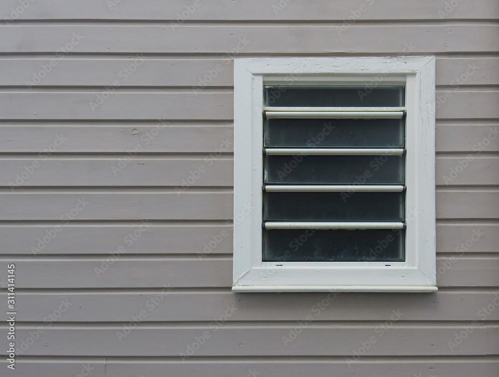 Close-up of white window on facade of horizontal sheets of painted wood. Tropical architecture. Martinique, French West Indies Close-up of white window on facade of horizontal sheets of painted wood. Tropical architecture. Martinique, French West Indies