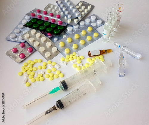 Pharmaceuticals. Antibiotics, various pills, syringes, ampoules on a white background.