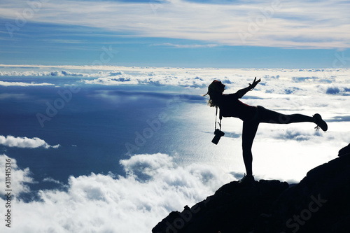 Young girl trekking and taking photos on Pico volcano (2351m) on Pico Island, Azores, Portugal, Europe