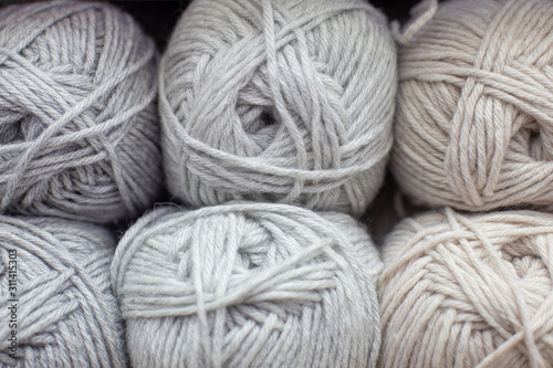 Beige and grey woolen threads in balls for knitting and handmade.