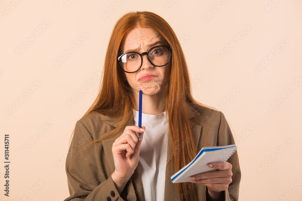 beautiful young woman with red hair in a jacket on a beige background beautiful young woman with red hair in a jacket on a beige background