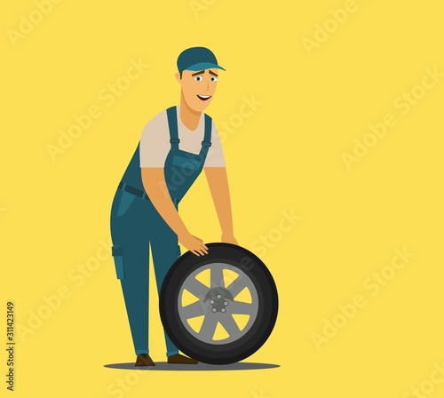 Young mechanic changing wheel at tire service