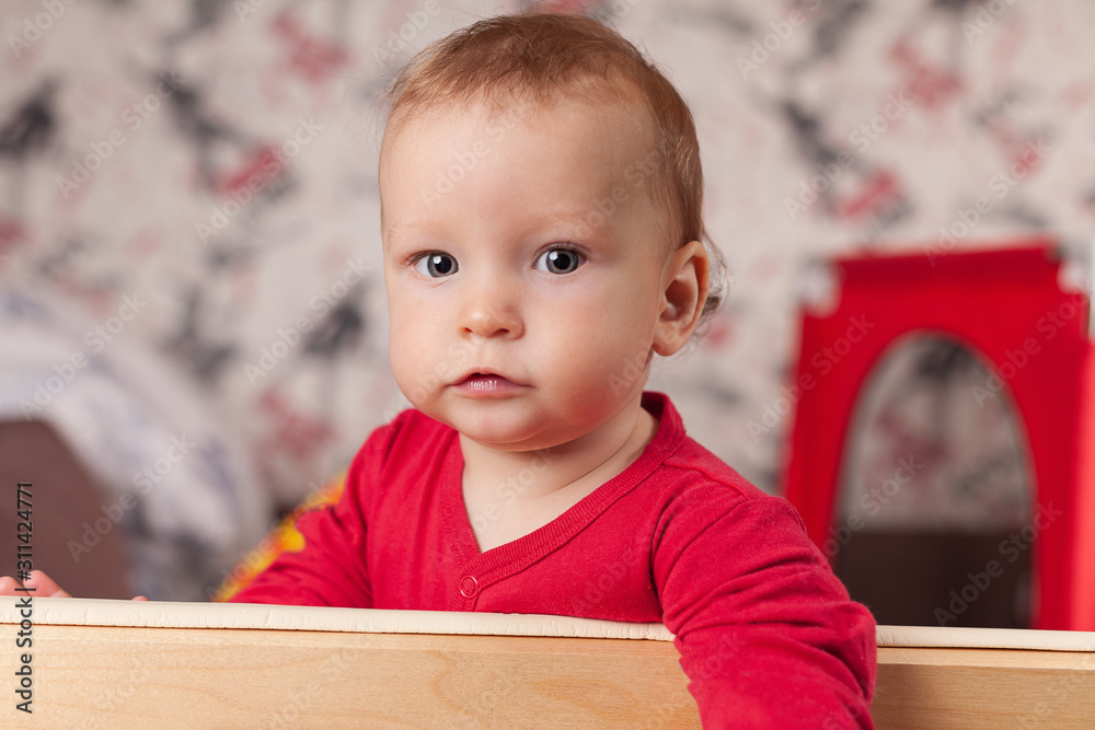 a small child stands and holds the edge of the bed or playpen in the nursery, happy and happy smiling baby, the concept of child development, the first steps, selfie, portret a small child stands and holds the edge of the bed or playpen in the nursery, happy and happy smiling baby, the concept of child development, the first steps, selfie, portret