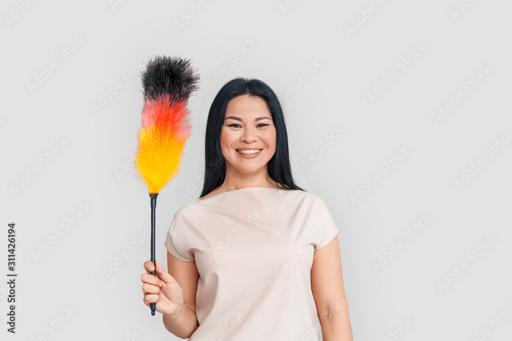 Freestyle. Asian woman standing isolated on white with duster smiling cheerful Freestyle. Asian woman standing isolated on white with duster smiling cheerful