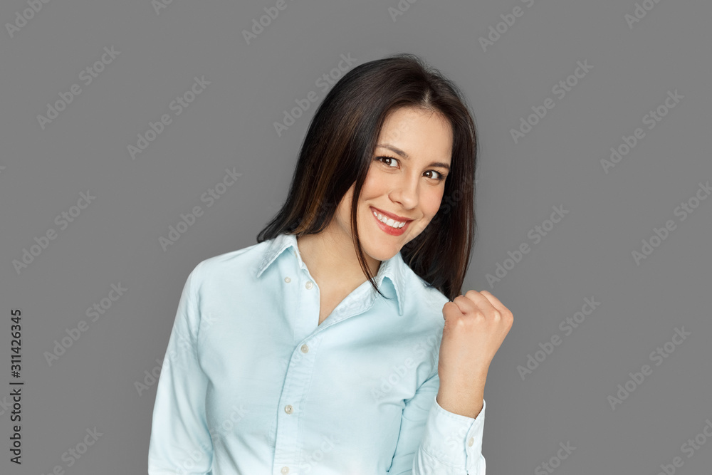 Freestyle. Young woman standing isolated on grey laughing playful to camera close-up Freestyle. Young woman standing isolated on grey laughing playful to camera close-up
