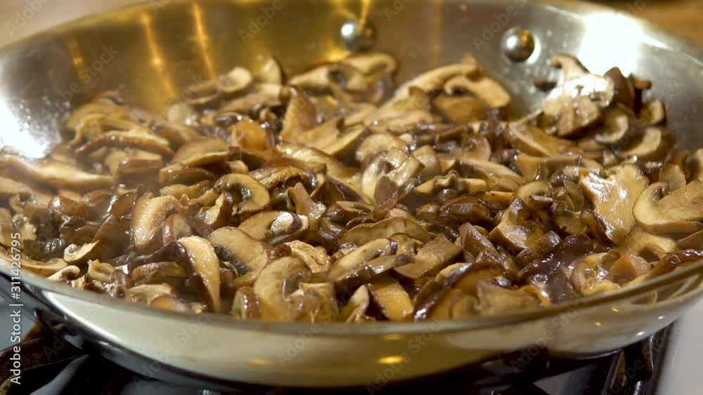 close up frying mushrooms in pan