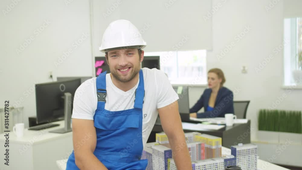 Smiling builder looks and nods his head at the camera Smiling builder looks and nods his head at the camera