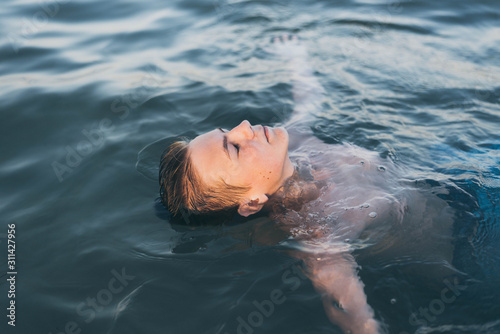 young teenage boy swimming in oceans water