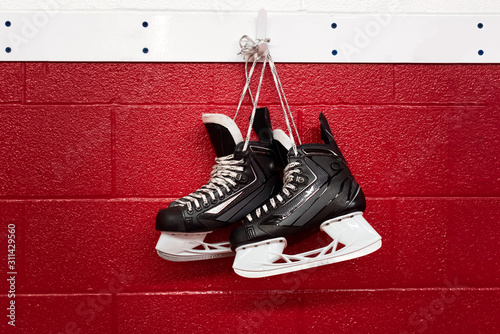 Photography Hockey skates hanging over red wall with copy space