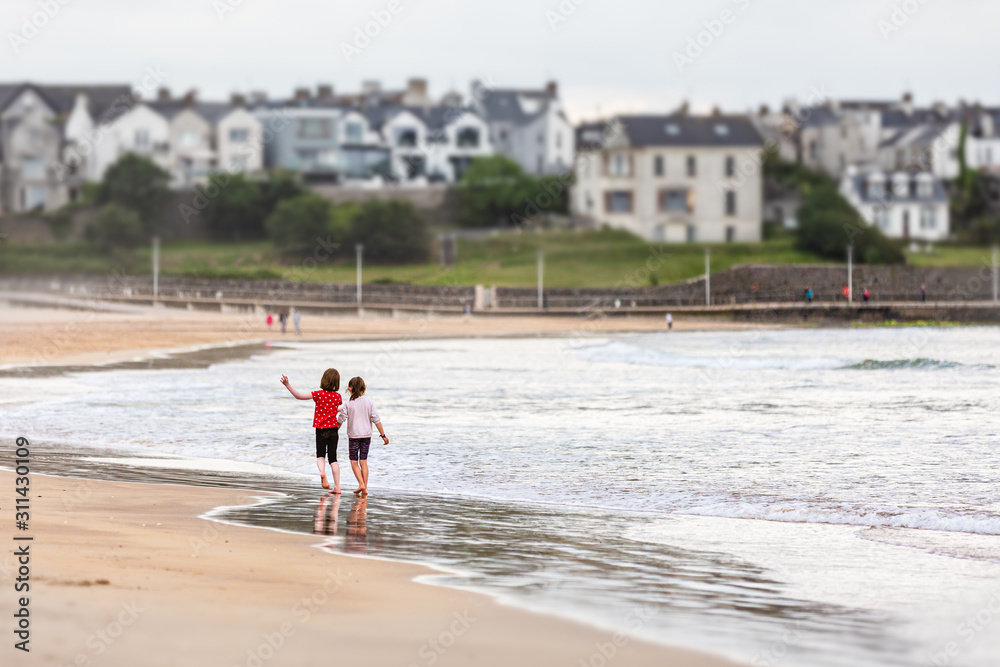 Children Paddle at Waters Edge East Strand Portrush Northern Ireland Children Paddle at Waters Edge East Strand Portrush Northern Ireland