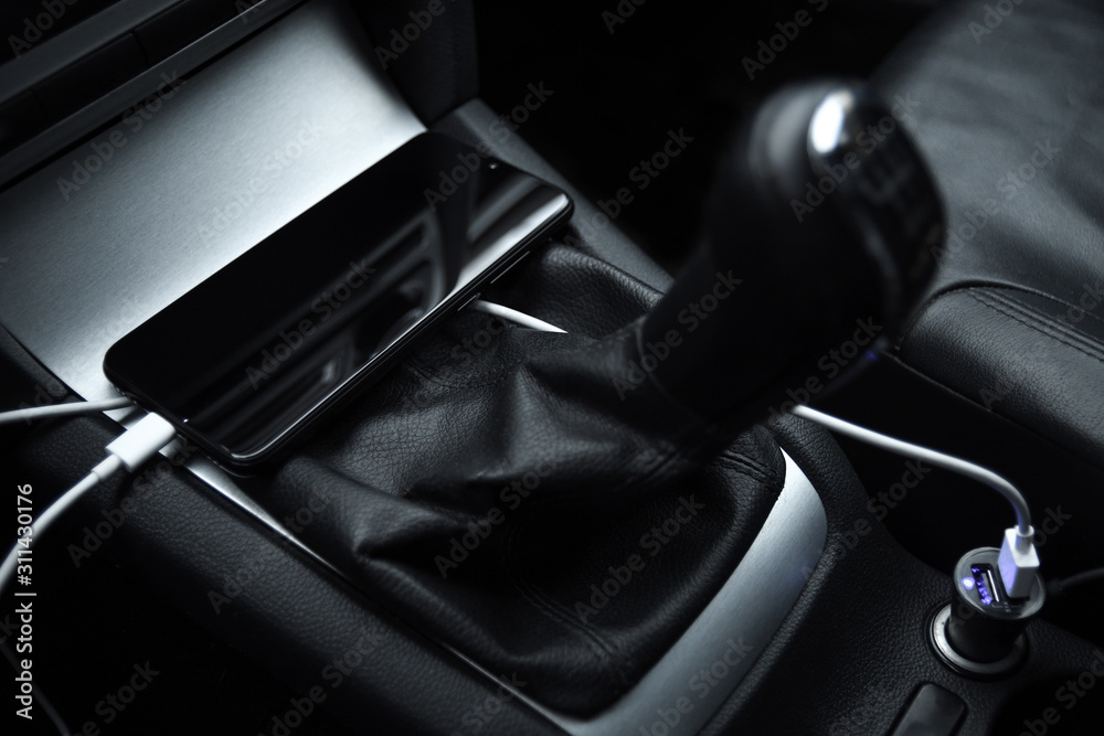 Obraz premium Mobile phone, smartphone charge battery , charging in the car plug close up