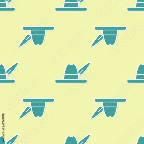 Green Oktoberfest hat icon isolated seamless pattern on yellow background. Hunter hat with feather. German hat.  Vector Illustration