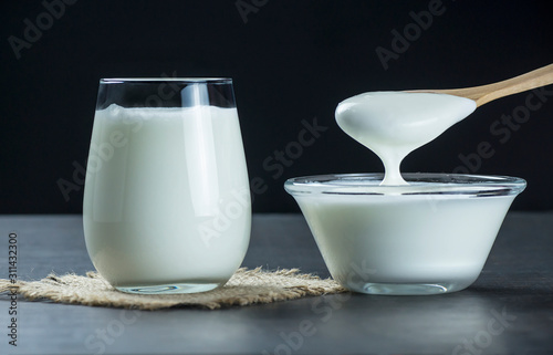 Glass cup of Turkish traditional drink ayran , kefir or buttermilk made from yogurt, homemade yoghurt in glass bowl on rustic table, healthy food