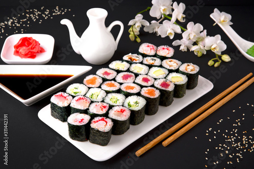 Sushi menu. Japanese food. Set of maki with salmon, tuna, chuka, cucumber, avocado, cheese, eel, shrimp, crab stick, tobiko caviar. Black background. Beautiful geometric food style.