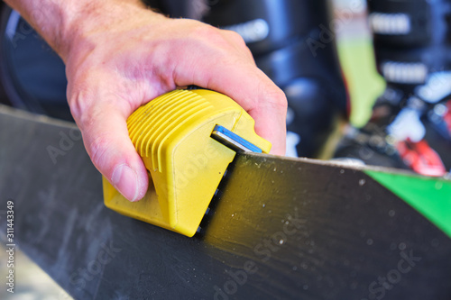 Obraz na płótnie Sharpening ski edges with a manual side-edge tuning tool fitted with a diamond stone. Focus on the tool sliding on the ski edge. w salonie