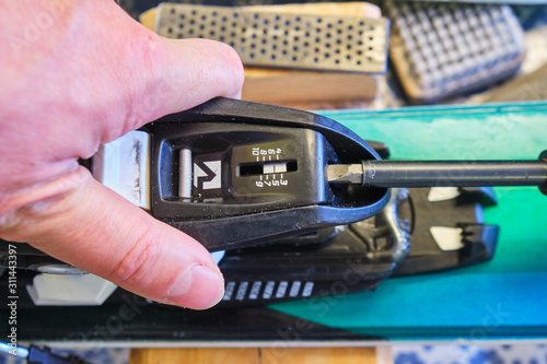 Adjusting DIN value (release setting) of a ski binding rear (heel) piece using a flathead screwdriver - focus on the scale with DIN values.